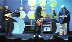 AMD CEO Hector Ruiz (left) jams with Slash and Gibson Guitar CEO Henry Juszkiewicz at Comdex in 2002. Ruiz gets praise for AMD's turnaround.