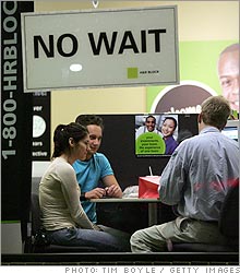 A tax preparer assists customers in an H&R Block office in Des Plaines, Illinois.