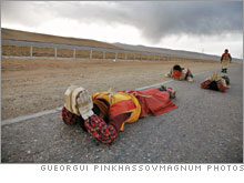 Buddhist pilgrims in prayful prostration along the railroad en route to a holy site.